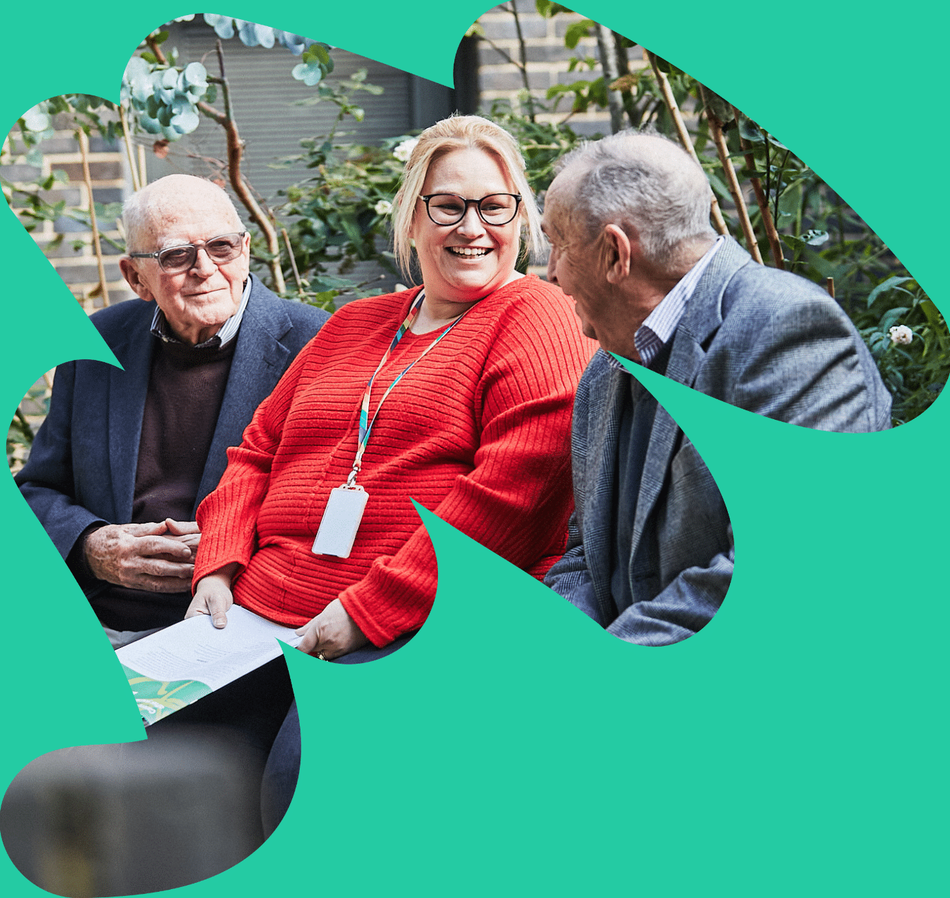 Sam Stevens, a woman in her thirties is sat with two older men on either side of her, all of them smiling