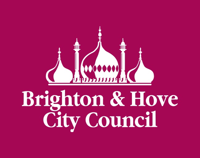 Photo of two white women outside with trees in the background. stood next to each other and smiling towards the camera. The woman on the left has long hair and the woman on the right has a short bobbed hair cut.