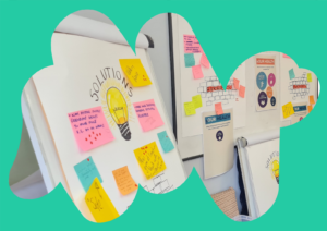 A Rethinking Our Health workshop space featuring flipcharts and whiteboards covered in colourful sticky notes. One flipchart is labelled "SOLUTIONS" with a hand-drawn lightbulb in the centre, surrounded by ideas on post-it notes. In the background, posters titled "YOUR HEALTH" and "BARRIERS" are visible, with more sticky notes and diagrams. The image is framed by an abstract teal shape.